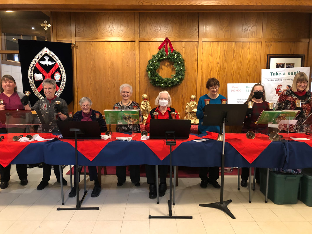 A photograph of the Handbell Choir taken in the greeting area before a Christmas service. They are lively!